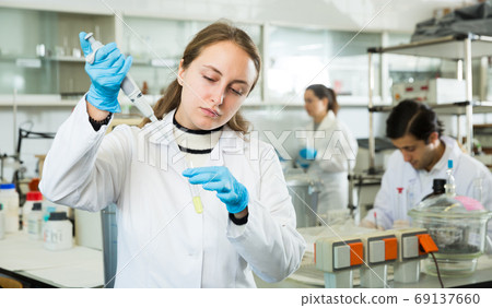Female student mixing chemicals Female student mixing chemicals 69137660