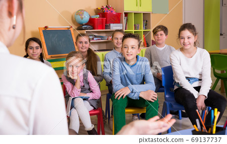 Glad boys and girls listening teacher Glad boys and girls listening teacher 69137737