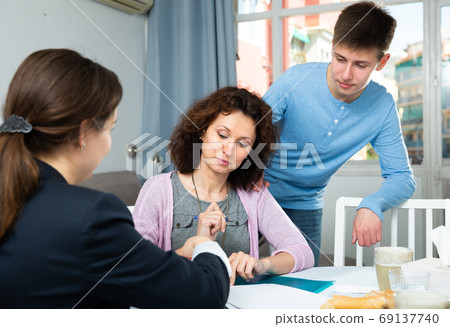 Woman and teenager discussing with lawyer Woman and teenager discussing with lawyer 69137740