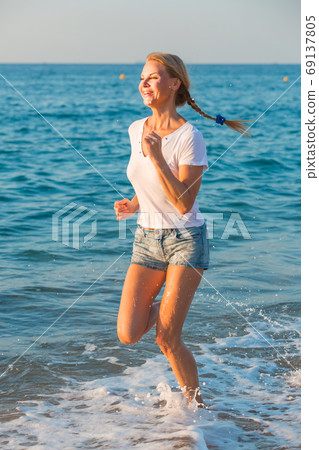 Female in white T-shirt is jogging Female in white T-shirt is jogging 69137805