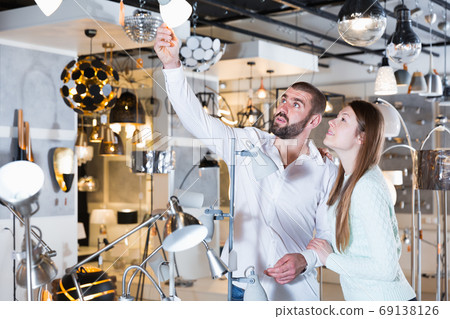 Portrait of family couple choosing floor lamp and other Portrait of family couple choosing floor lamp and other 69138126