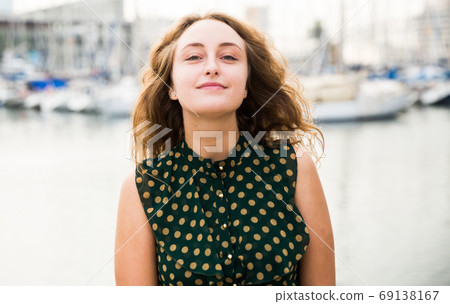 Close up of young attractive woman tourist at quay with sailboats Close up of young attractive woman tourist at quay with sailboats 69138167