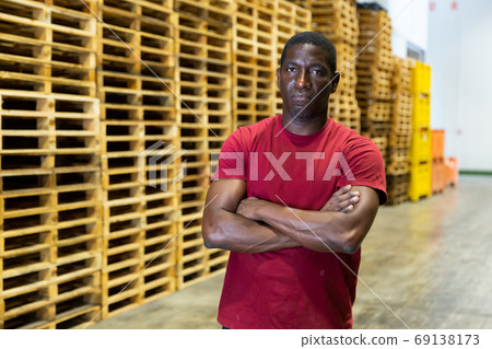 Portrait of afro american with arms crossed at warehouse of fruit packing factory Portrait of afro american with arms crossed at warehouse of fruit packing factory 69138173