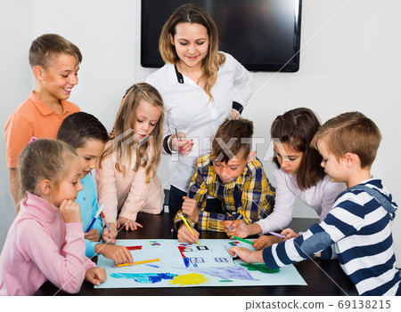 Children with teacher drawing together in classroom 69138215