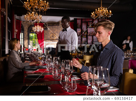 Man with glass of white wine Man with glass of white wine 69138417