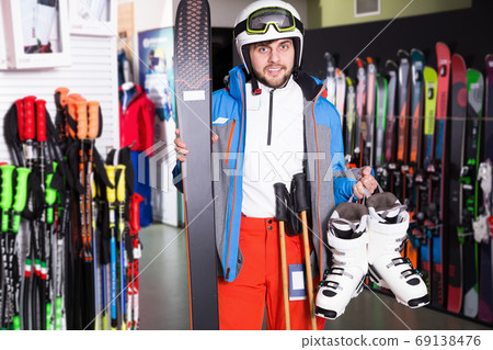 Smiling man posing in skiing gear in sport equipment shop Smiling man posing in skiing gear in sport equipment shop 69138476