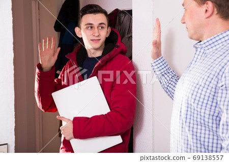 Guy is saying goodbye his father when is leaving to school Guy is saying goodbye his father when is leaving to school 69138557
