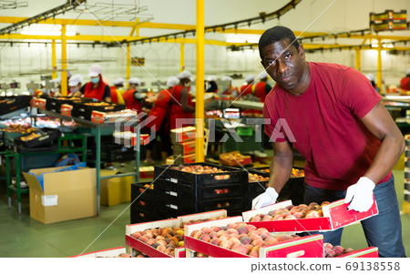 Confident male worker standing near boxes Confident male worker standing near boxes 69138558