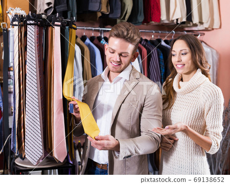 Couple choosing tie in store Couple choosing tie in store 69138652