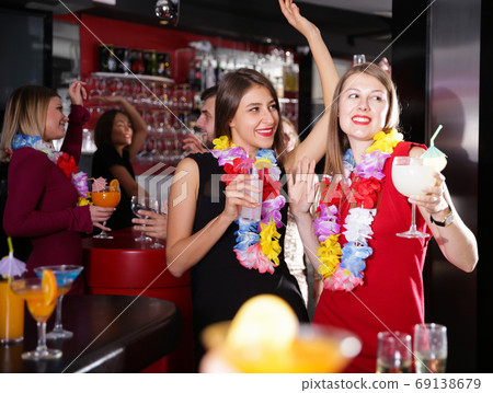 Female colleagues on company party in Hawaiian style in bar 69138679
