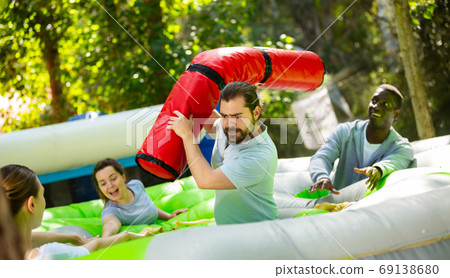 Bearded guy fighting off friends with inflatable log Bearded guy fighting off friends with inflatable log 69138680