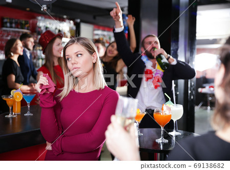 Girl upset with drunk boyfriend on Hawaiian party in bar Girl upset with drunk boyfriend on Hawaiian party in bar 69138682