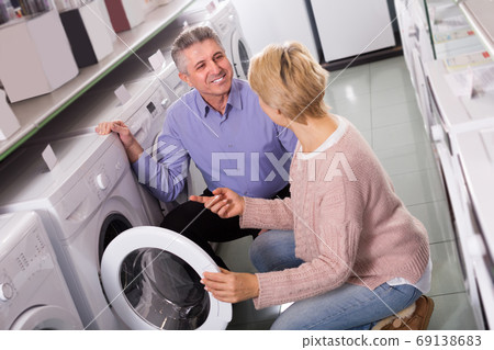 Couple are choosing home modern washing machine Couple are choosing home modern washing machine 69138683