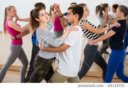 Group of teen dancing salsa in dance studio Group of teen dancing salsa in dance studio 69138781