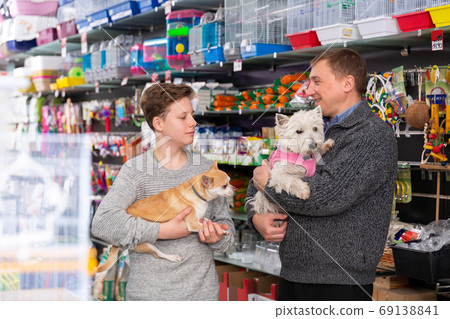 Portrait of friendly family with dogs visiting pet supplies shop Portrait of friendly family with dogs visiting pet supplies shop 69138841