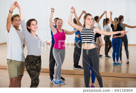 Group of teen dancing salsa in dance studio Group of teen dancing salsa in dance studio 69138904