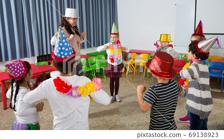 School kids with teacher in festive hats having fun School kids with teacher in festive hats having fun 69138923
