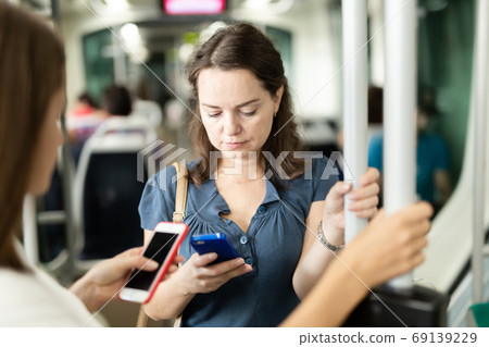 Brunette with smartphone in bus 69139229