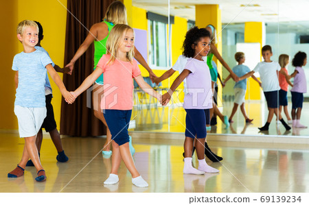 Children with teacher dancing in circle 69139234