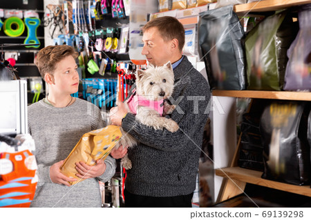 Father and son with dog buying vet food in petshop 69139298
