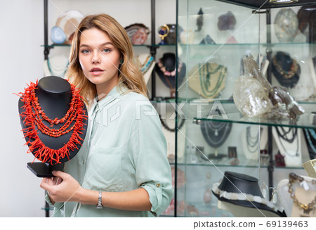 Salesgirl offering necklaces of precious corals 69139463
