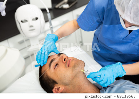 Man receiving carboxytherapy procedure at beauty clinic 69139565