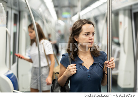 Nice women with handbag in subway car 69139759