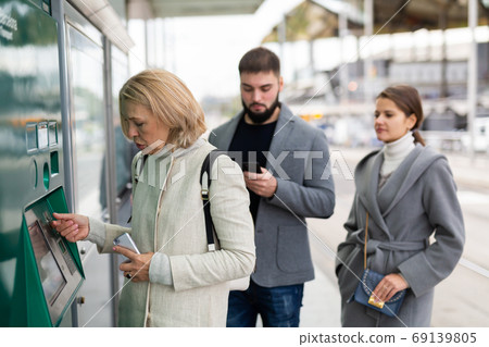 Mature woman buying ticket for public transport 69139805