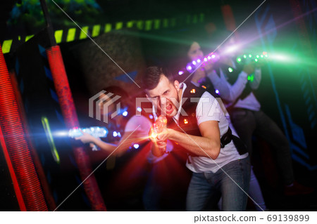 Excited guy laser tag player in bright beams Excited guy laser tag player in bright beams 69139899