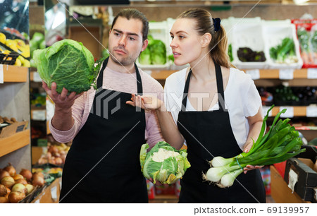 Two sellers inspecting vegetables Two sellers inspecting vegetables 69139957