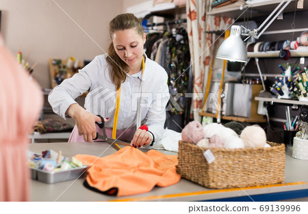Woman professional working cut material at sewing atelier Woman professional working cut material at sewing atelier 69139996