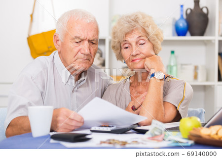Upset retired couple calculating domestic finances Upset retired couple calculating domestic finances 69140000
