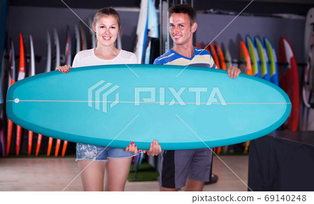 couple is posing in surfboard store on the beach. 69140248