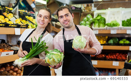 Two sellers offering vegetables 69140333
