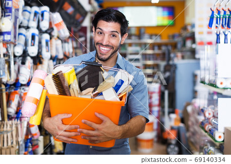 Man with purchases in paint store 69140334