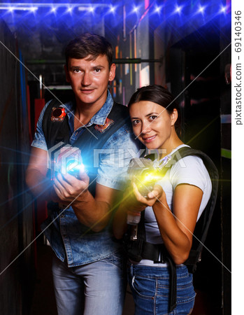 couple holding colored laser guns during laser tag game couple holding colored laser guns during laser tag game 69140346