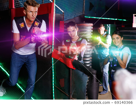 Portrait of friends standing with laser guns during laser tag g 69140366