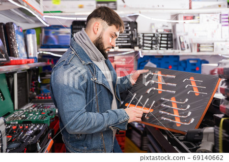 Man is buying new ratchet in tools store Man is buying new ratchet in tools store 69140662