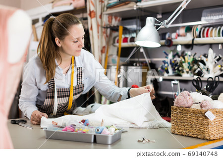 Woman professional working with material at sewing workshop 69140748