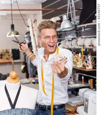 Portrait of happy blond male tailor 69140757
