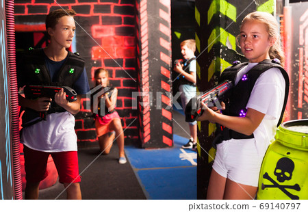 Teen kids during lasertag game Teen kids during lasertag game 69140797