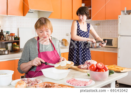 Woman and her daughter making dinner 69141042