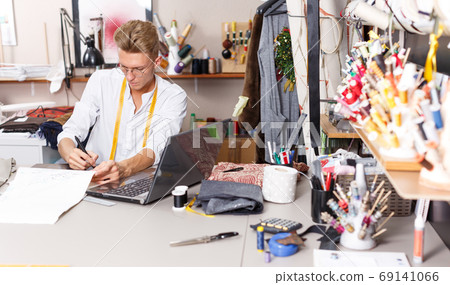 Tailor using laptop and graphics tablet Tailor using laptop and graphics tablet 69141066