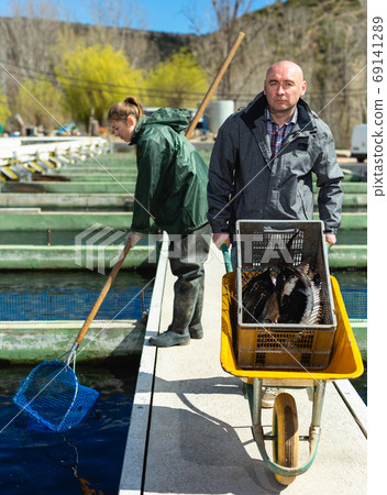 Man and woman working at fish farm 69141289