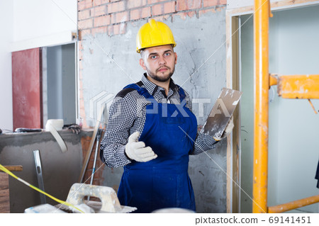 Male ready is plastering the wall Male ready is plastering the wall 69141451