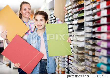 Mother and daughter choosing paper Mother and daughter choosing paper 69141469