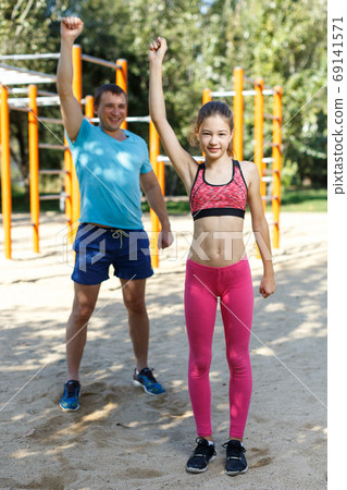 Girl doing exercises with father Girl doing exercises with father 69141571