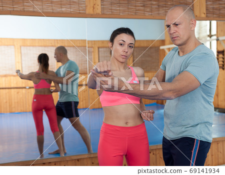 Womens self-defense workout with personal trainer, fighting training in gym 69141934