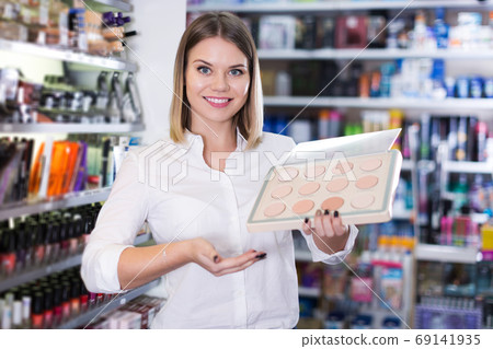 saleswoman helping to choose powder in beauty store 69141935