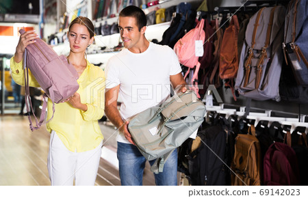 Couple choosing new backpack at store 69142023
